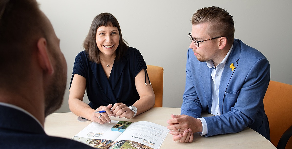 Der Vorstand der EthikBank - Katrin Spindler, Toni Scheller und Thomas Meyer - sitzt zusammen an einem Tisch.